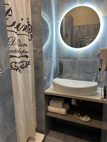 bagno con lavandino e specchio di Family Residence Boutique Apartments 4 a Lviv