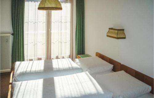 クシュニッツにあるAmazing Apartment In Gschnitz With 2 Bedrooms And Wifiのベッド3台と窓が備わる客室です。