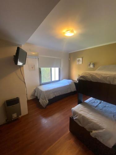 a hotel room with two beds and a television at Chalet San Rafael in San Rafael