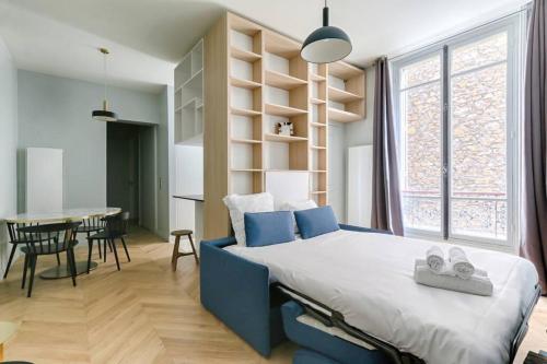 een slaapkamer met een groot bed en een tafel met stoelen bij Champs Elysées Marbeuf Magnifique Appartement 4P in Parijs