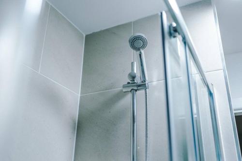 a shower with a shower head in a bathroom at Beautiful Bradford Home Sleeps 8 with Parking by PureStay Short Lets in Wibsey