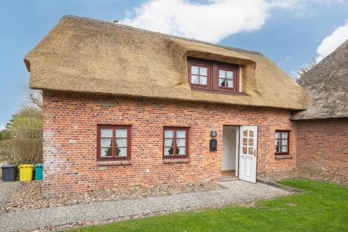 an old brick house with a thatched roof at Kleine Kate in Keitum