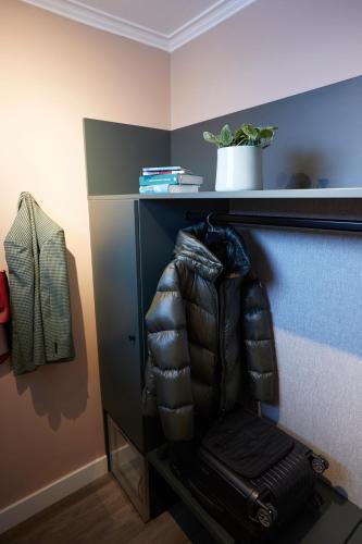 a shelf with a leather chair in a room at Hotel Metropol by Maier Privathotels in Munich