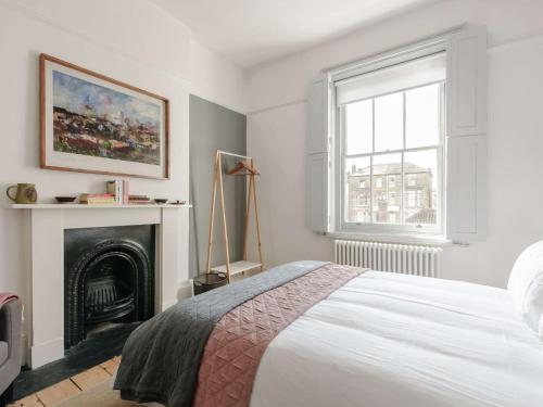 a white bedroom with a bed and a fireplace at 4 bed property in Broadstairs 80679 in Broadstairs