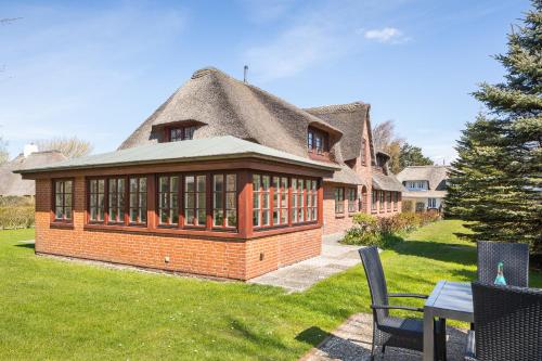 a large brick building with a thatched roof at Aalernhues in Keitum