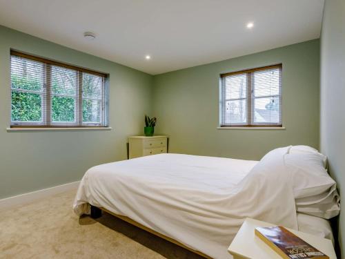 a bedroom with a white bed and two windows at 2 bed in Sherborne 80735 in Wootton Glanville