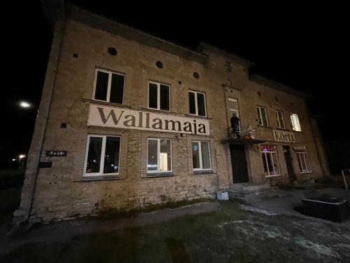 a building with a sign on the side of it at night at Tamsalu Wallamaja in Tamsalu