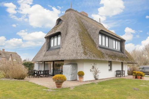 a thatch roofed house with a thatched roof at Uaster Reeg III Studio in Archsum