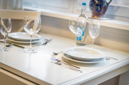 a table with plates and wine glasses on it at Uaster Reeg III Studio in Archsum