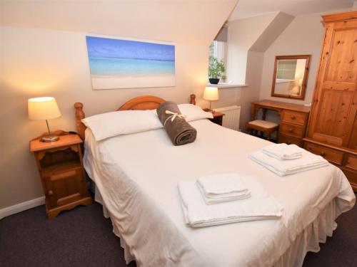 een slaapkamer met een bed met twee handdoeken erop bij 2 Bed in Cosheston FB059 in Cosheston