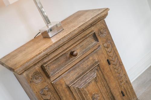 a wooden cabinet with a lamp on top of it at Takerhof Galerie Wohnung 10 in Keitum
