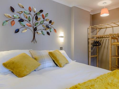 1 Bed in 78725 في Tanfield: غرفة نوم بسرير أبيض مع شجرة على الحائط