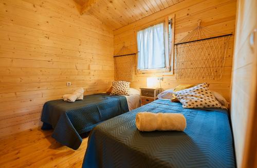 1 dormitorio con 2 camas en una cabaña de madera en Villa Experience Rural en Ronda
