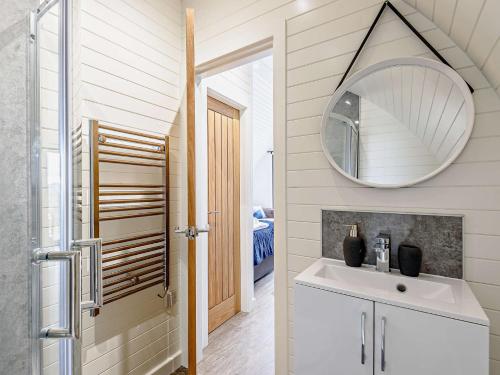 un bagno con lavandino e specchio di 2 Bed in Corwen 80318 a Gwyddelwern