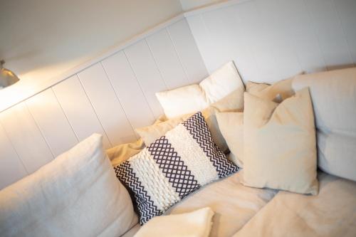a pile of pillows sitting on top of a bed at Lille Hygge in Keitum