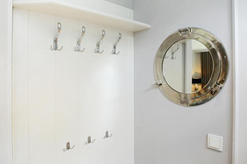 uma casa de banho com um espelho e uma parede branca em Litz Hues em Keitum
