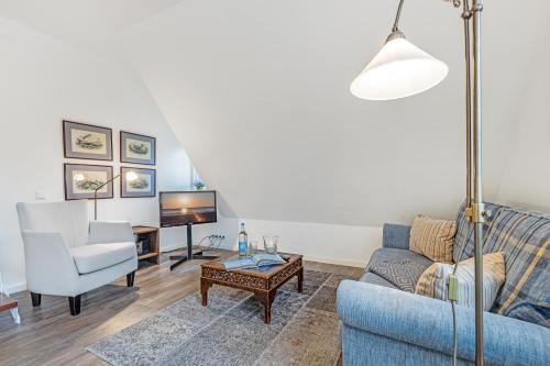 a living room with a blue couch and a tv at Sueder Ech in Keitum
