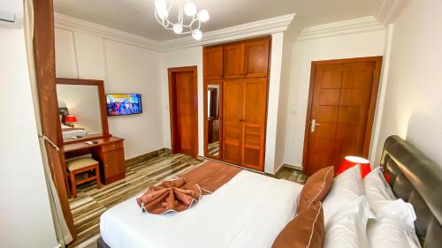 a bedroom with a bed with a brown purse on it at BELMANN BONAPRISO in Douala