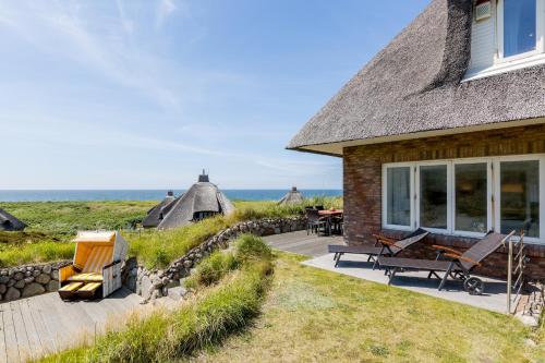 a house with a patio and a view of the ocean at Smuk Hus in Hörnum