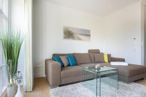 a living room with a couch and a glass table at Gode Tiet in Westerland (Sylt)