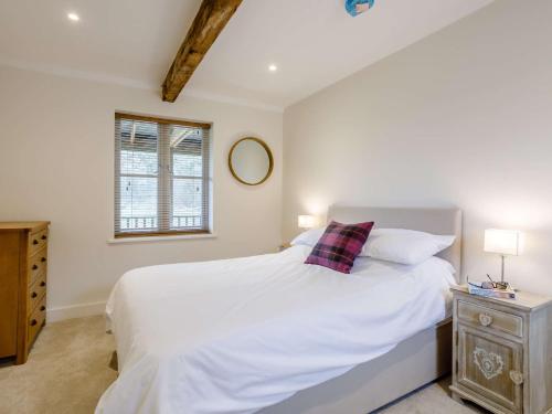 a bedroom with a white bed and a window at 1 bed in Sherborne 80737 in Wootton Glanville