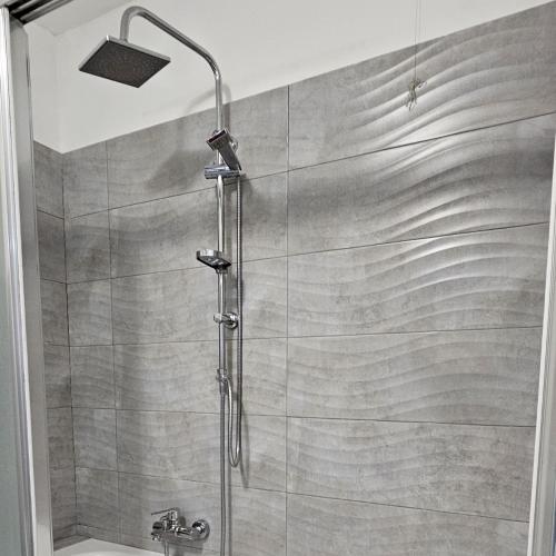 een douche met een douchekop in de badkamer bij Casa Moderna Olgiate in Olgiate Olona