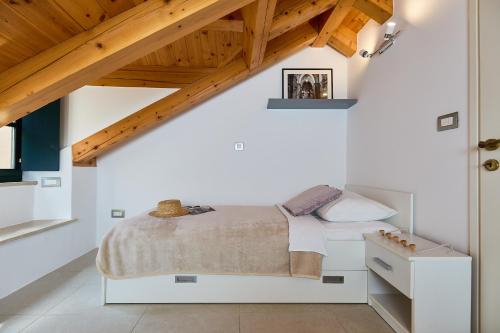 sypialnia z białym łóżkiem i drewnianym sufitem w obiekcie B18 APARTMENT w Dubrowniku