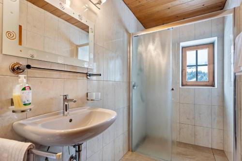 uma casa de banho com um lavatório e um chuveiro em Schwüwong - Apartment 12 em Kelchsau