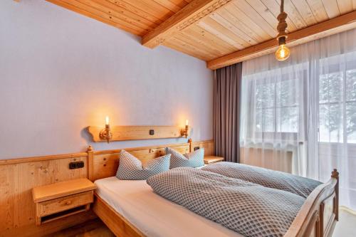 um quarto com uma cama e uma janela em Schwüwong - Apartment 12 em Kelchsau