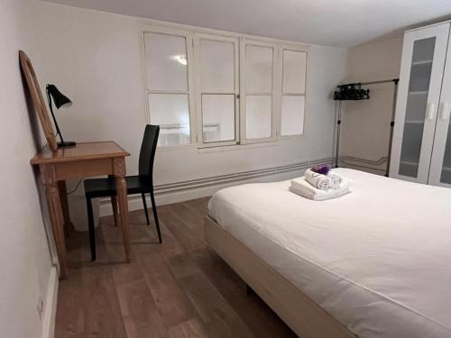 um quarto com uma cama, uma secretária e uma cadeira em Le Berriat YourHostHelper em Grenoble