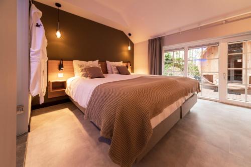 a bedroom with a large bed and a large window at 't Eekhoornnest in Soest