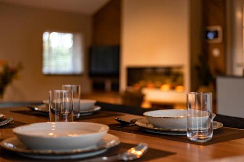a wooden table with plates and bowls and glasses on it at 't Eekhoornnest in Soest