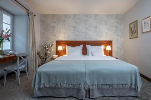 a bedroom with a large bed and a desk at Monastery Garden Prague in Prague