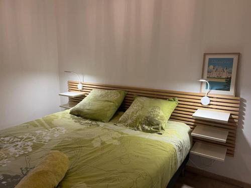 een slaapkamer met een bed met een houten hoofdeinde bij La Villa Coquette in Vouvray