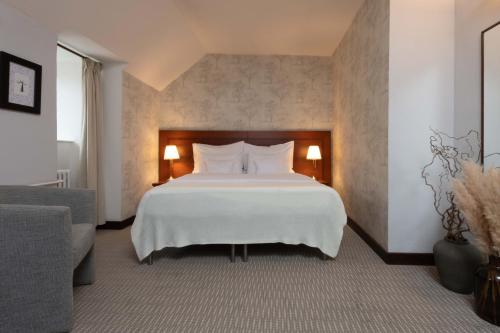 a bedroom with a large white bed and a couch at Monastery Garden Prague in Prague