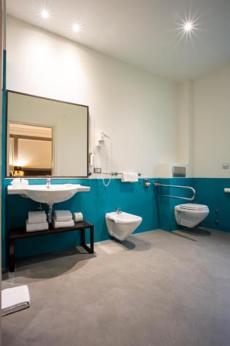 a bathroom with two toilets and a sink and a mirror at Elizabeth Lifestyle Hotel in Bologna