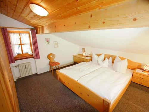 1 dormitorio con 1 cama grande en una habitación de madera en Haus Lux, en Reit im Winkl