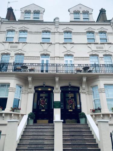 a white building with stairs in front of it at The Avonmore Olympia in London