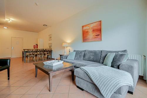 a living room with a couch and a table at Appartement Wijde Blick 110 - aan de duinen - Callantsoog in Callantsoog