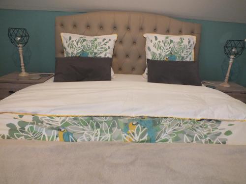 a bedroom with a large bed with two lamps at B&B Le Club de la Source in Hannut