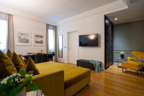 a living room with a yellow couch and a tv at Elizabeth Lifestyle Hotel in Bologna
