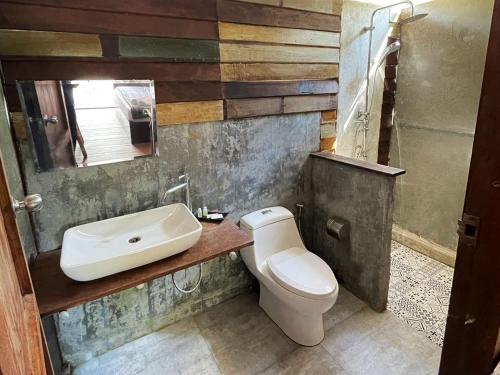 a bathroom with a sink and a toilet at Little Hut in Ko Phayam
