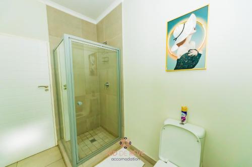 uma casa de banho com uma cabina de duche em vidro e um WC. em Nid de Rêve Accommodation em Midrand