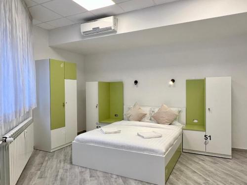 Un dormitorio con una cama blanca con detalles verdes en Appa Hostel, en Zagreb