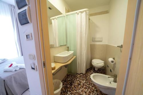 bagno con lavandino e servizi igienici di Gargano Hotel Helios a Rodi Garganico