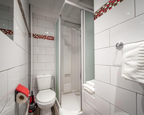 a white bathroom with a toilet and a shower at Hotel Van Eyck in Bruges