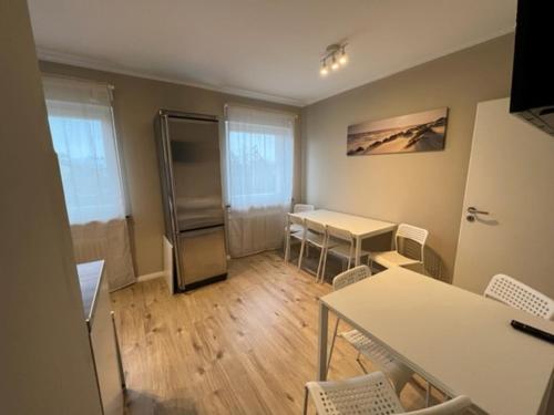 Cette chambre comprend un réfrigérateur, une table et des chaises. dans l'établissement Secrets Design Apartment, à Rodenbach