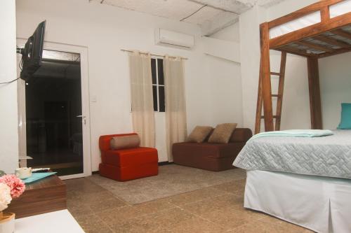 a bedroom with a bed and a couch and a chair at Sunset View - Mini Loft in La Libertad