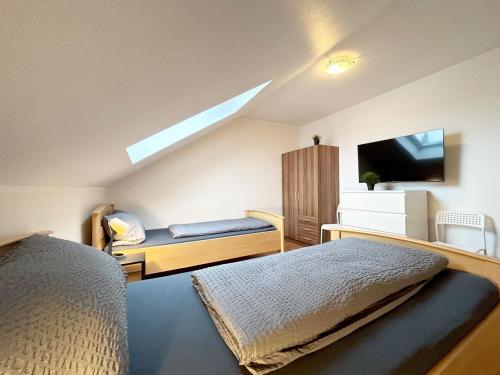een slaapkamer met een bed en een tv en een bank bij Nice Apartment in Büchenberg in Eichenzell