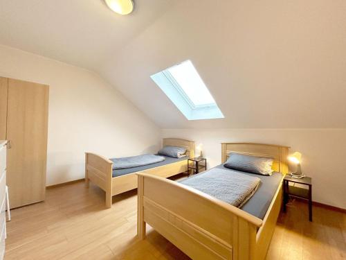 een slaapkamer met 2 bedden en een dakraam bij Nice Apartment in Büchenberg in Eichenzell